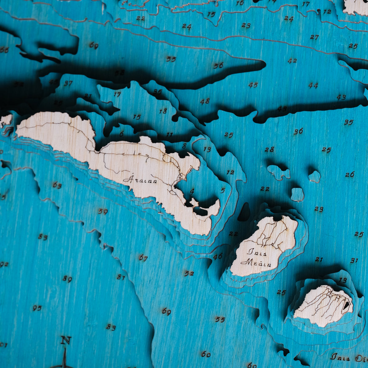 Aran Islands detail showing the Aran Islands and the sea bed in layers of blue around them. The sounding depths and full bathymetry is shown and the three Islands are shown in full detail with the tracks and roads also engraved into the bamboo.