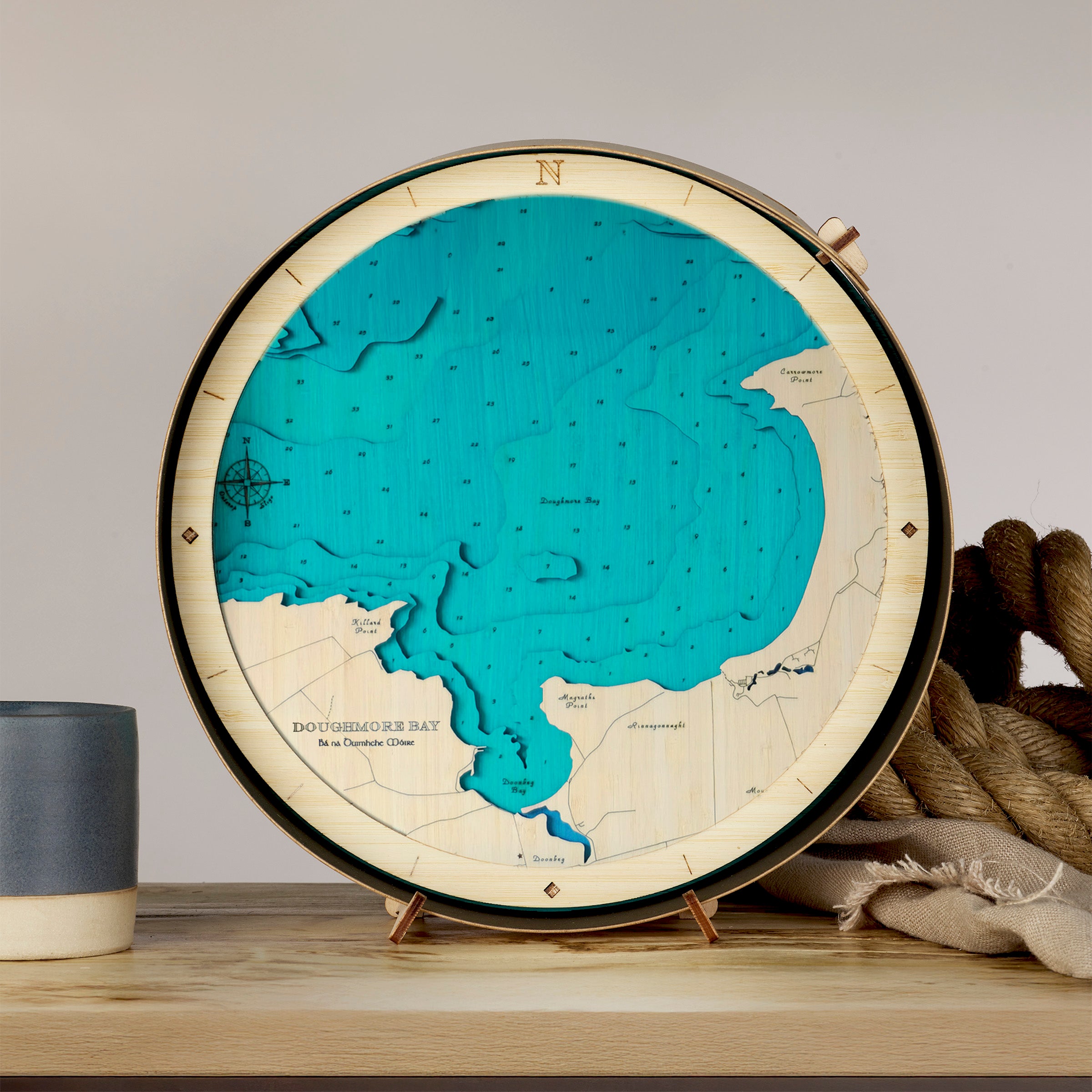 Round Wooden map of Doughmore Bay County Clare on a stand with a gray background