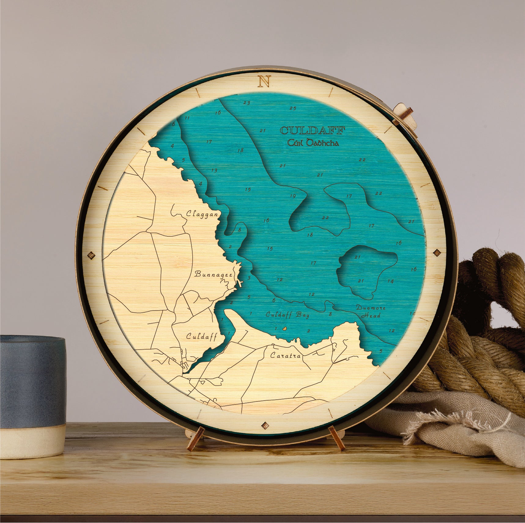 Wooden map model of Colldaff on a stand with a cup and rope in the background.