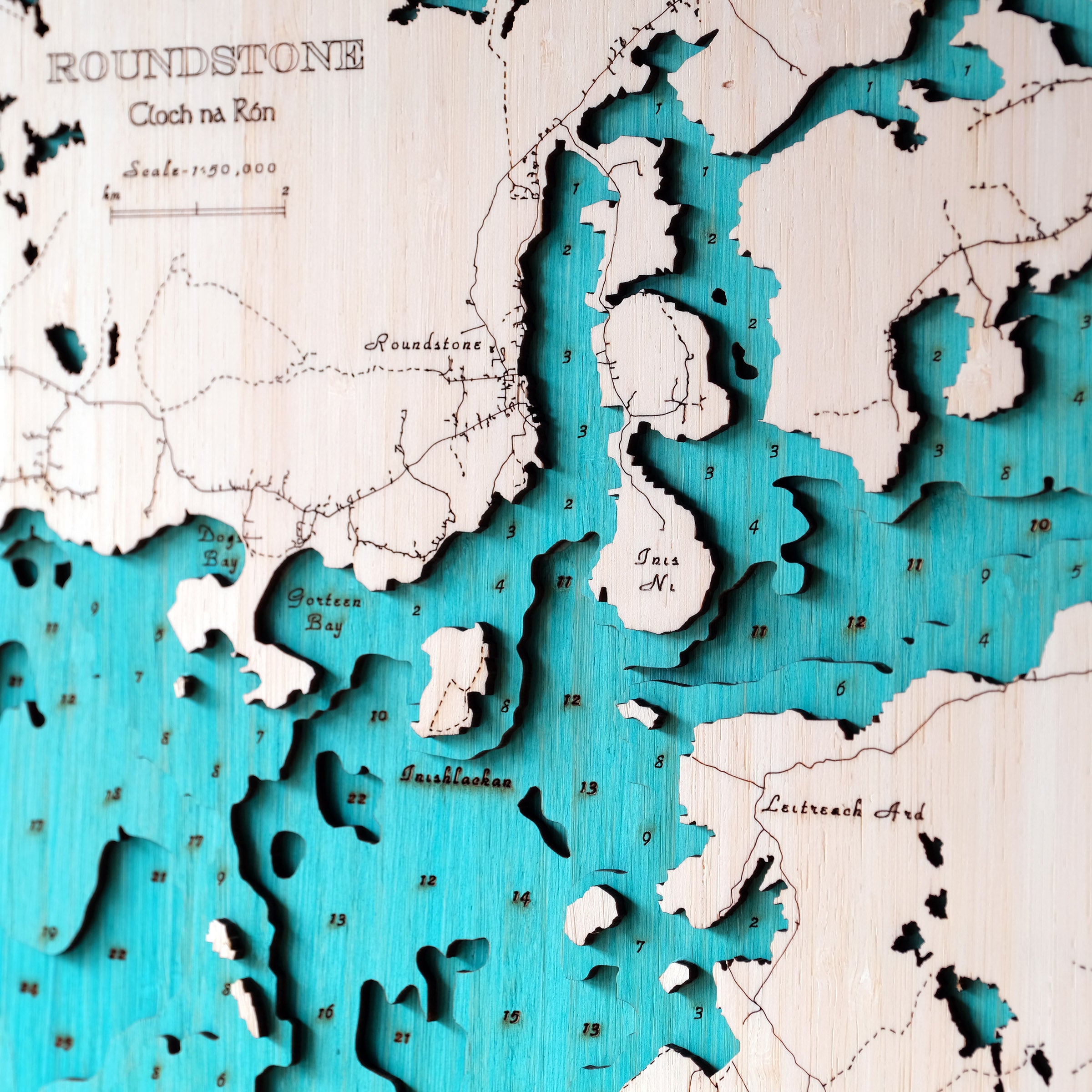 Wooden map with cut-out topography, featuring a blue and white color scheme.