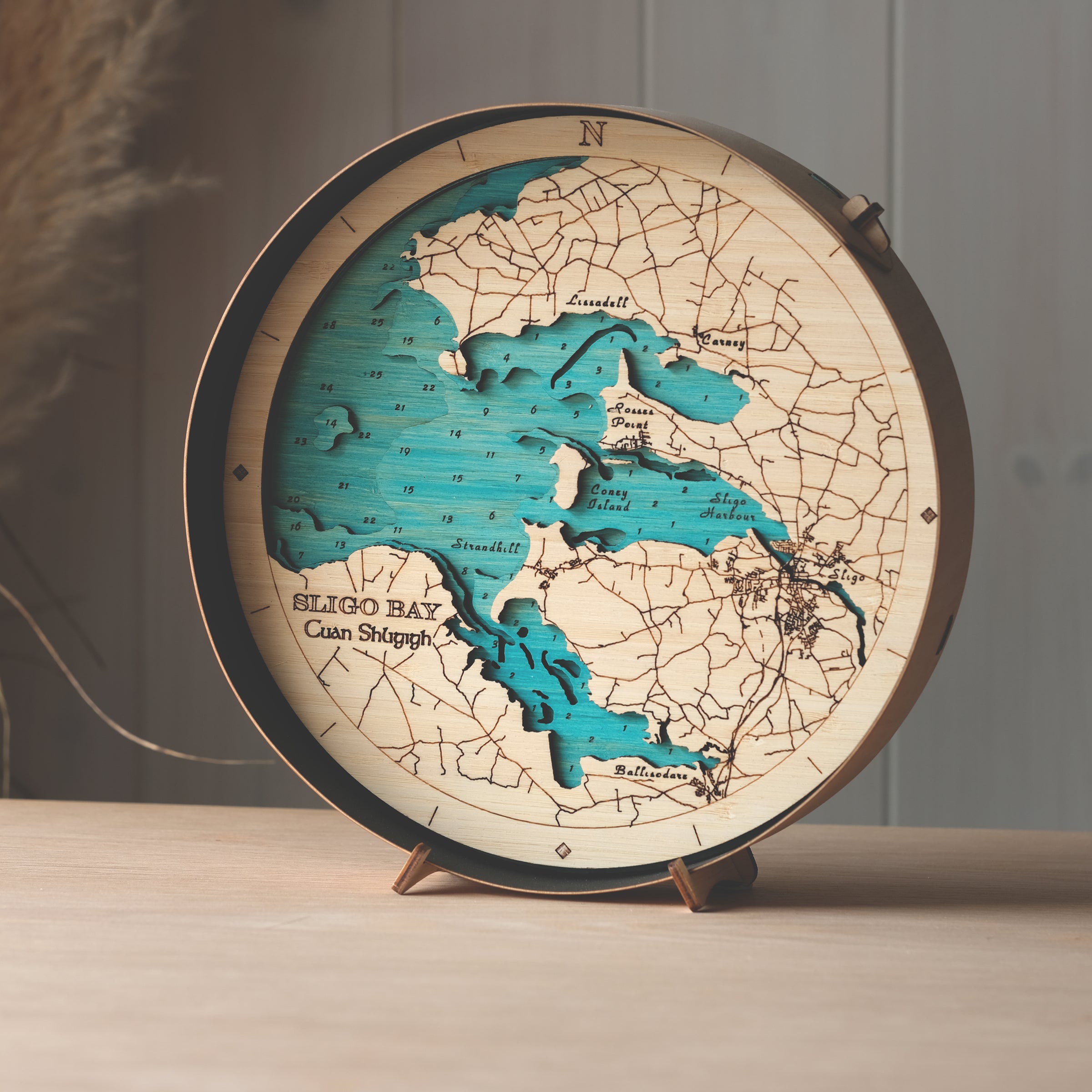Round 3D wooden map of Sligo Bay in black birch frame, displayed on a shelf with stand, handcrafted by Outcrop