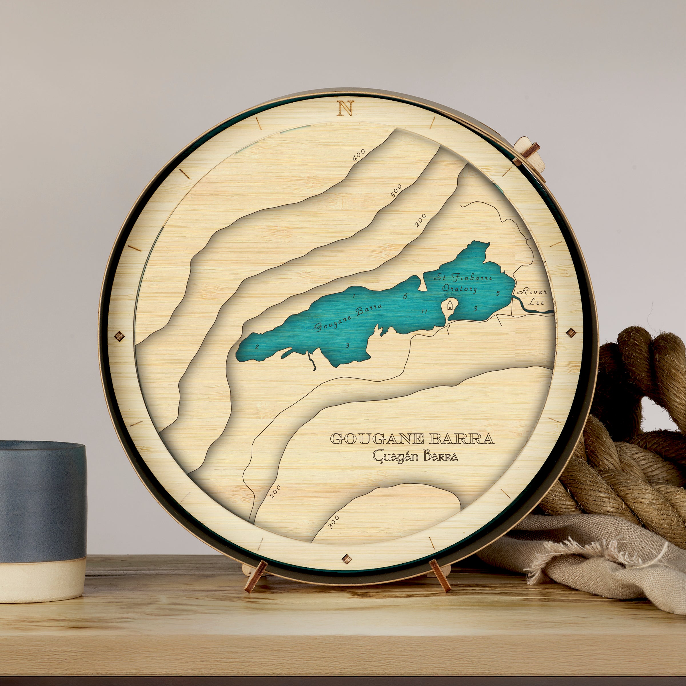 3D wooden map of Gougane Barra Lake, Co. Cork, showing layered lake contours in a handcrafted round sustainable frame.