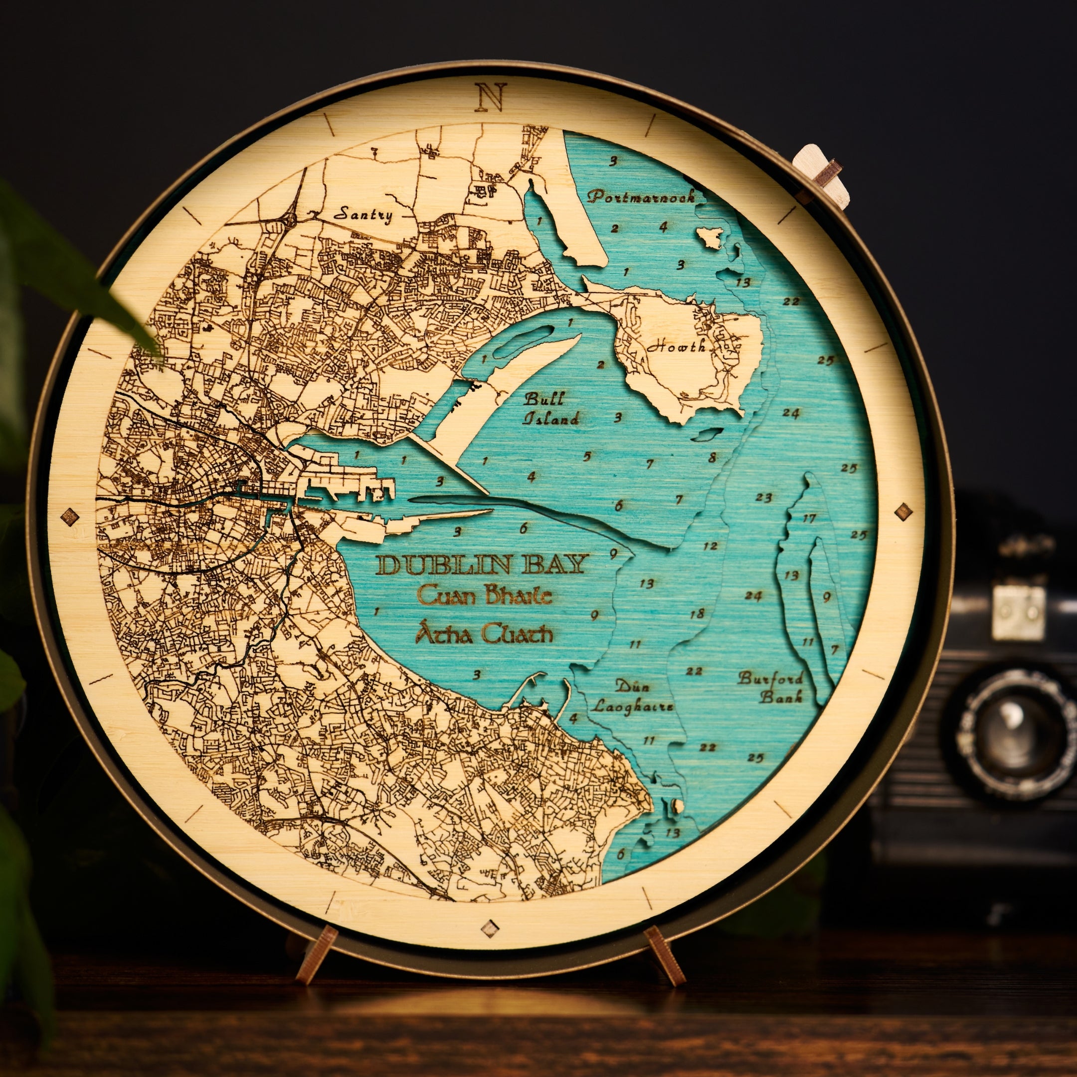 Dublin Bay round wooden map with black frame on table 