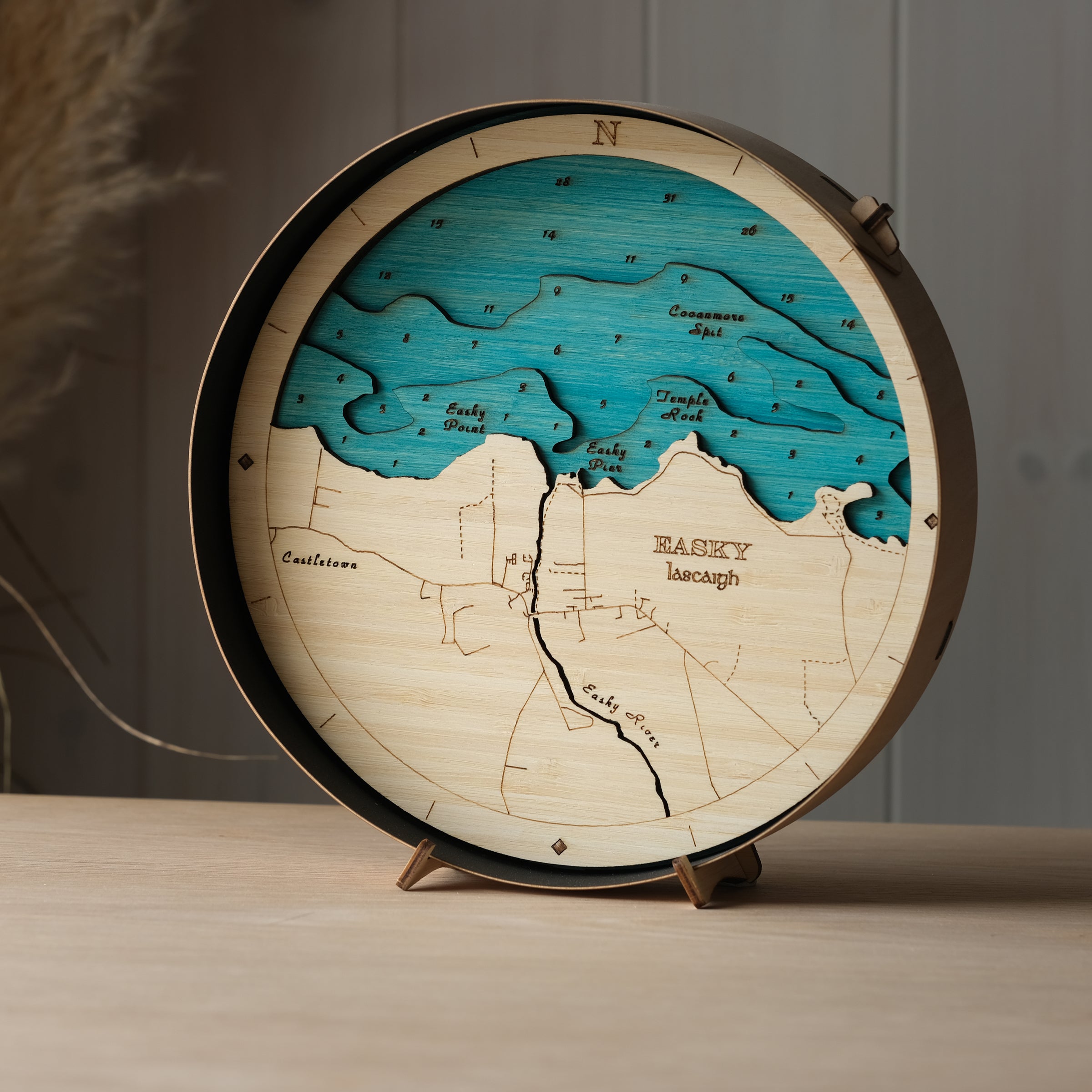 Round 3D wooden map of Easkey in black birch frame, displayed on a shelf with stand, handcrafted by Outcrop