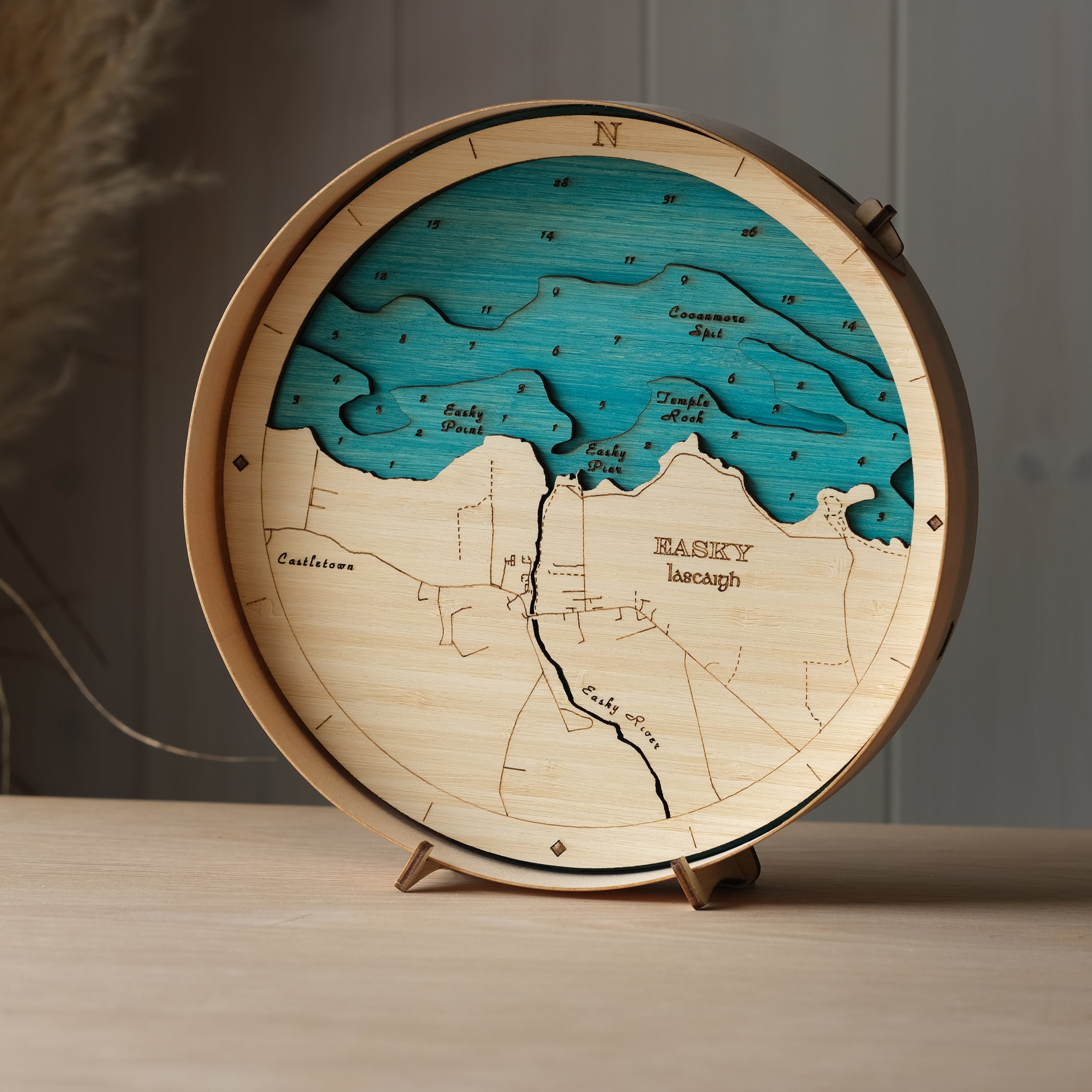 Round 3D wooden map of Easkey in natural birch frame, displayed on a shelf with stand, handcrafted by Outcrop