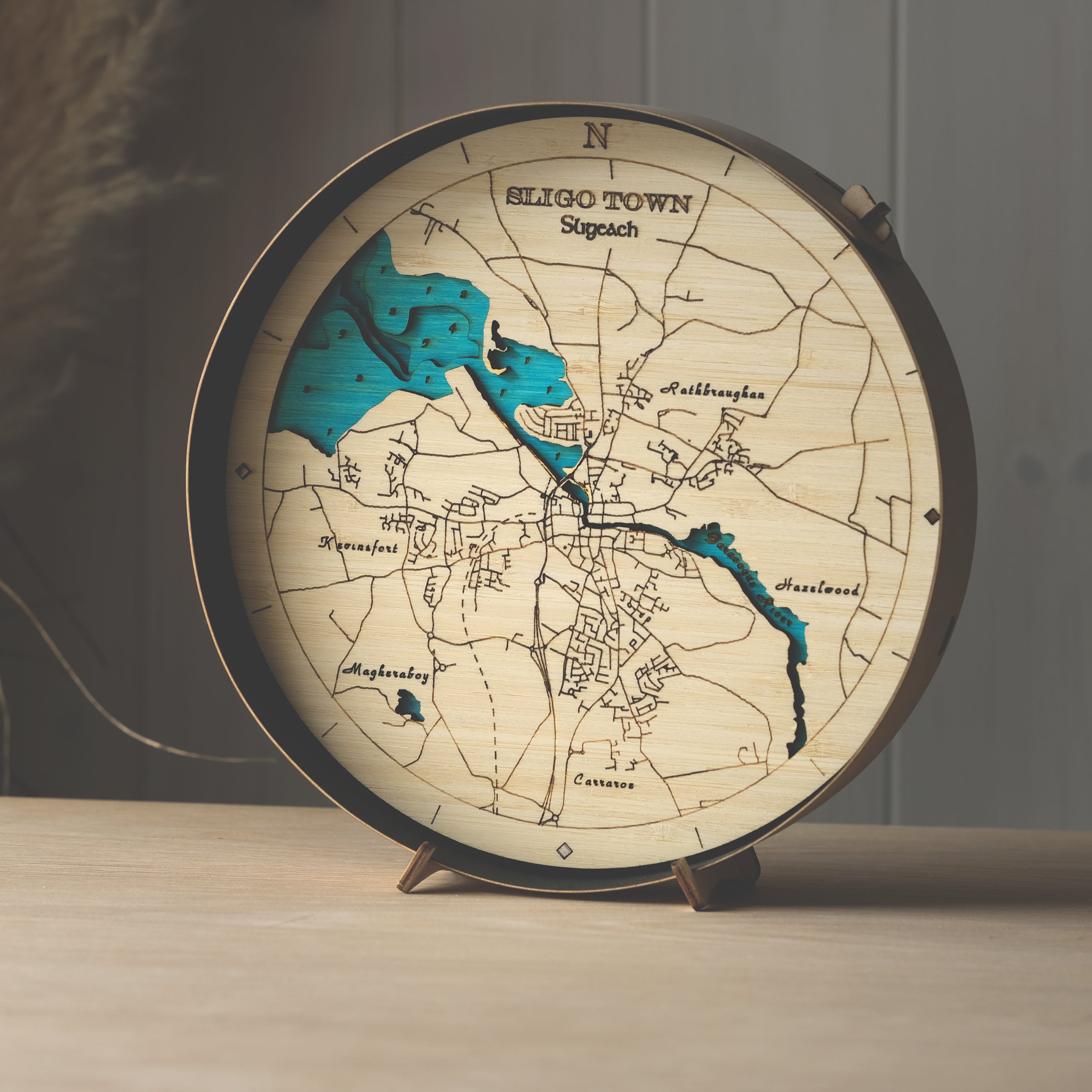 Round 3D wooden map of Sligo town in black birch frame, displayed on a shelf with stand, handcrafted by Outcrop