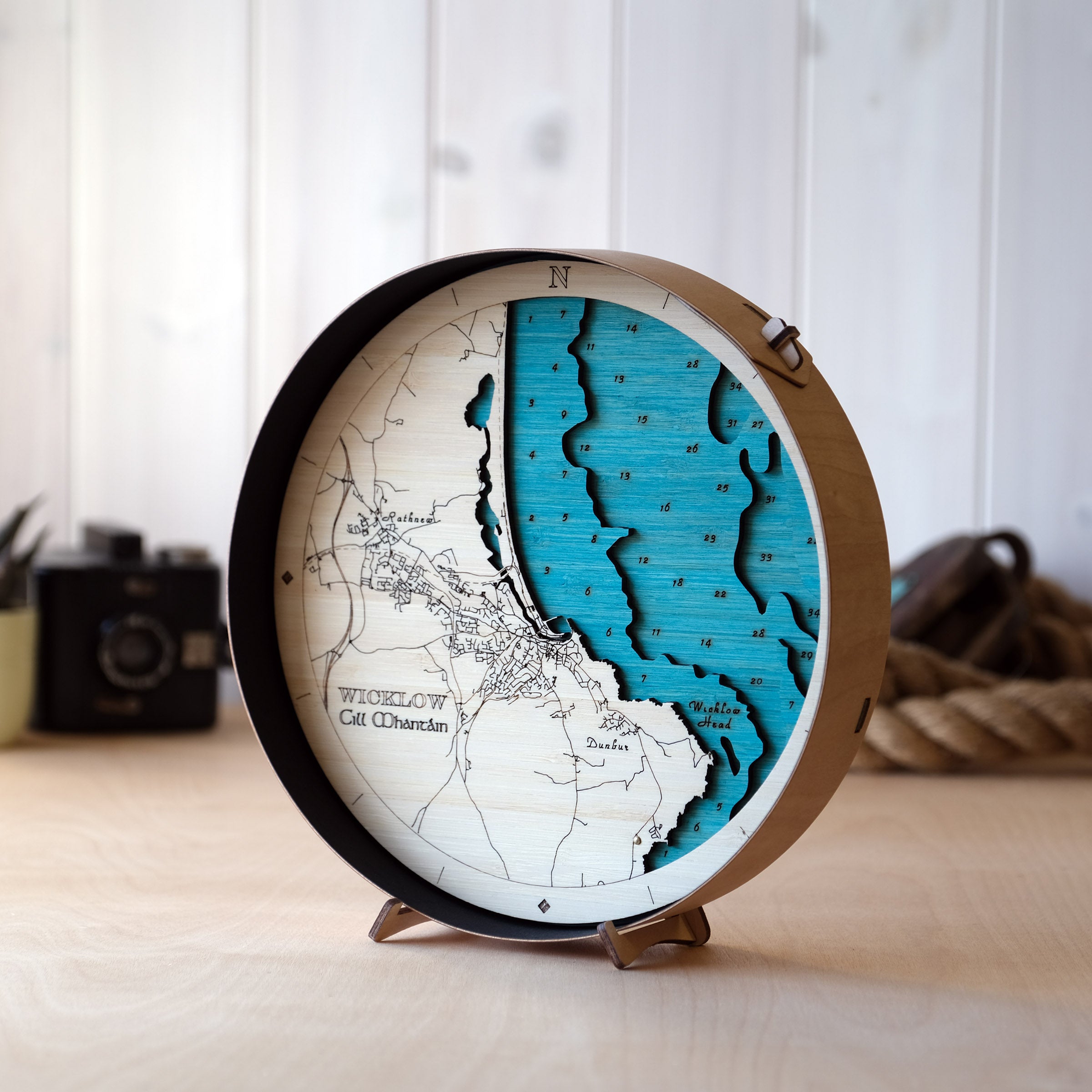 3D wooden map of Wicklow Town and Wicklow Head showing layered coastline, harbour and lighthouse in a round sustainable frame.