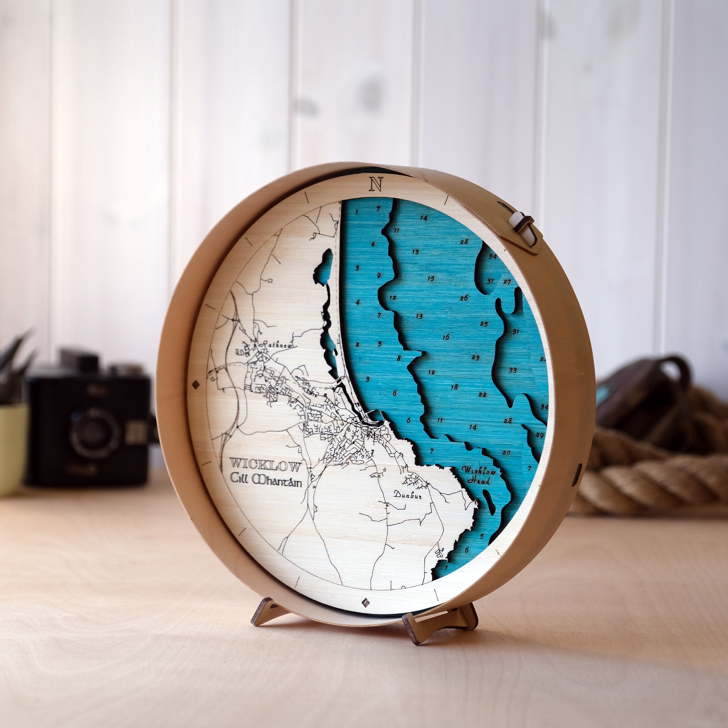 3D wooden map of Wicklow Town and Wicklow Head showing layered coastline, harbour and lighthouse in a round sustainable frame.